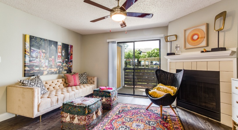 a living room with a rug, couch, and a fan at The Lorenzo