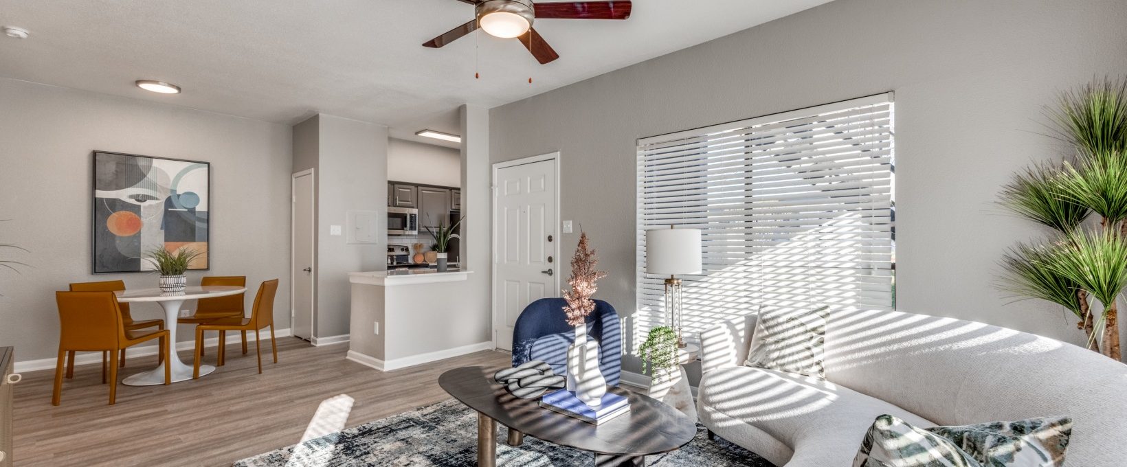 a living room with a ceiling fan and white walls at The Pearce on  Lake