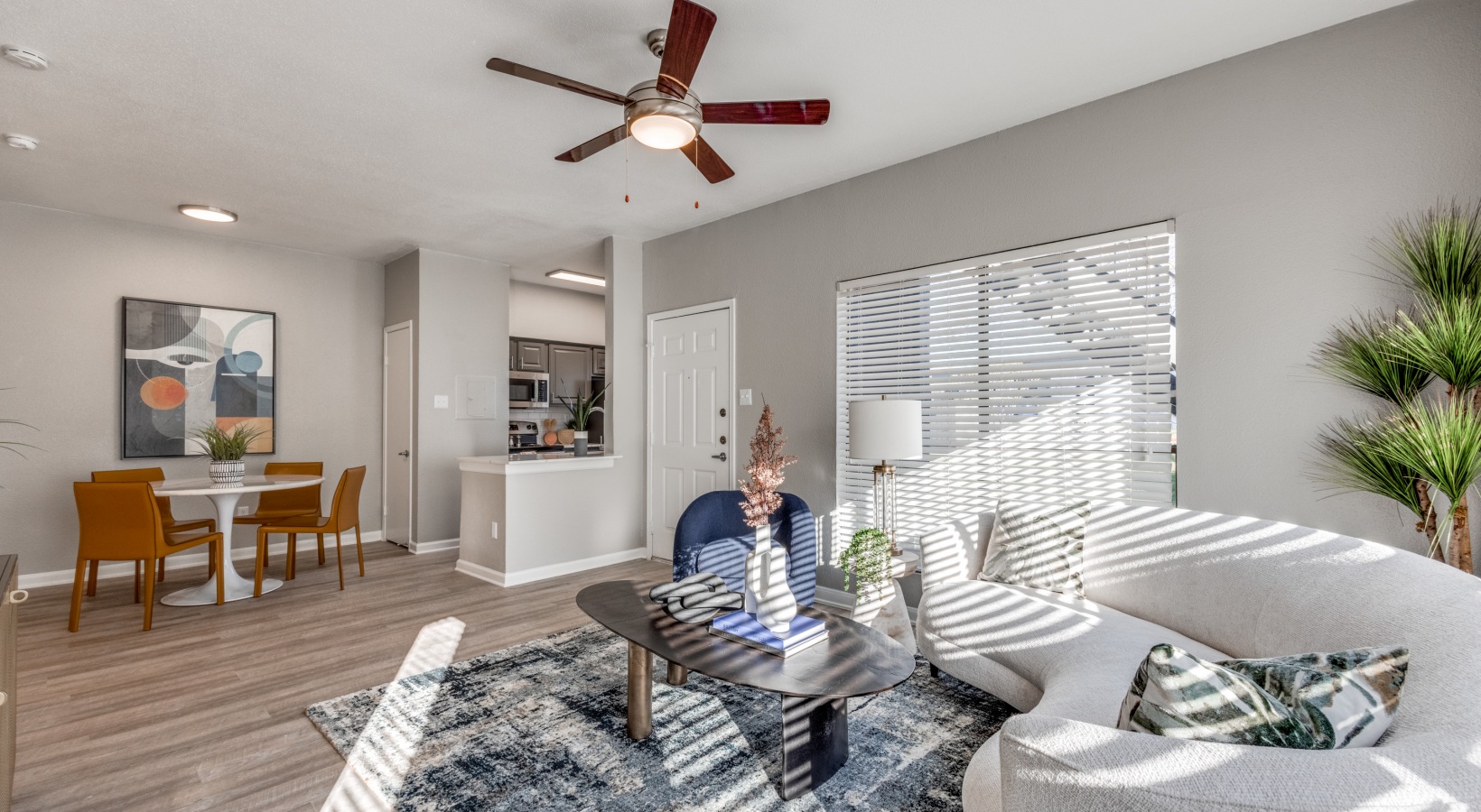a living room with a ceiling fan and white walls at The Pearce on  Lake