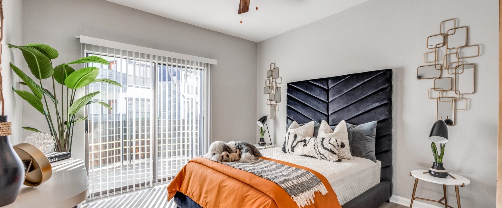 a bedroom with a bed, a ceiling fan and a large window at The Pearce on  Lake