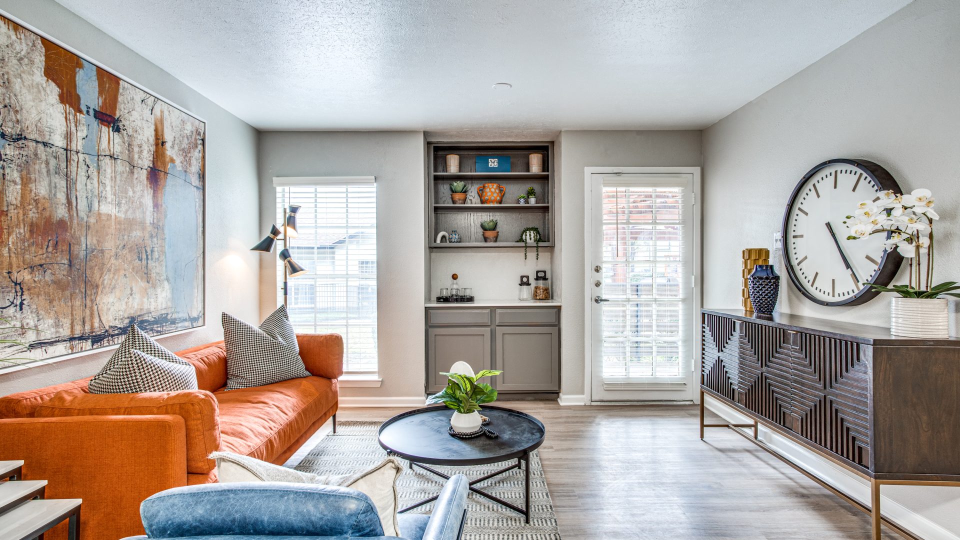 a living room with a blue couch and a clock at The Richmond