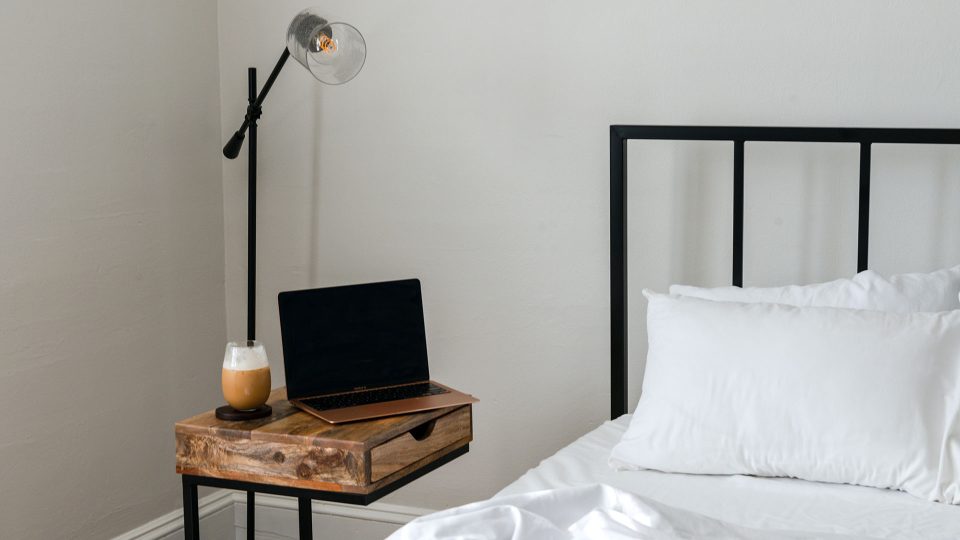 a bed with a laptop on it and a lamp at The The Huxley