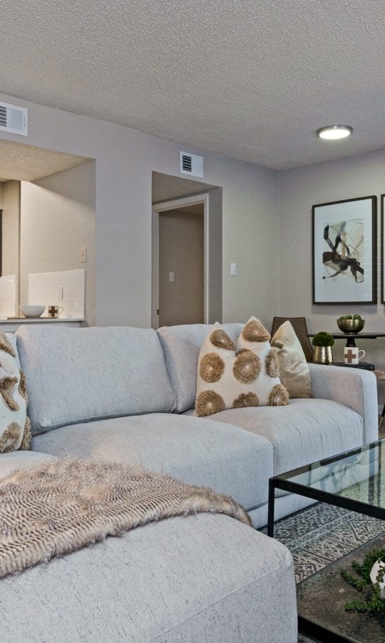 a living room with a couch, coffee table and television at The The Huxley