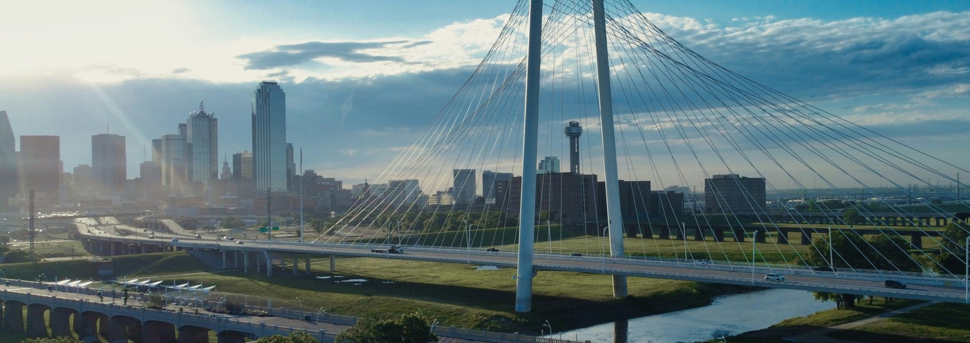 a bridge over a river with a city in the background