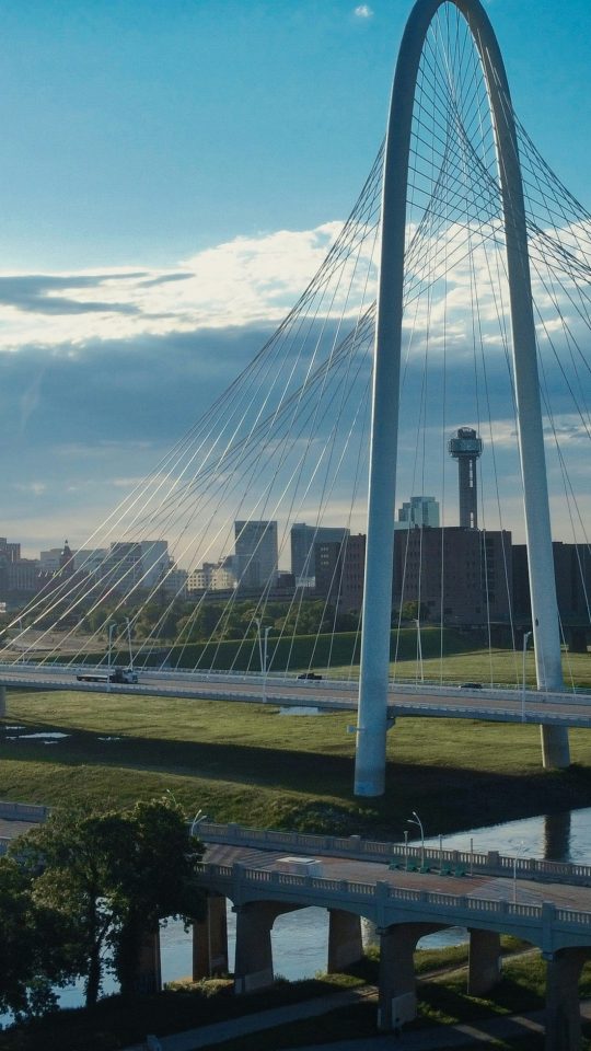 a bridge over a river with a city in the background