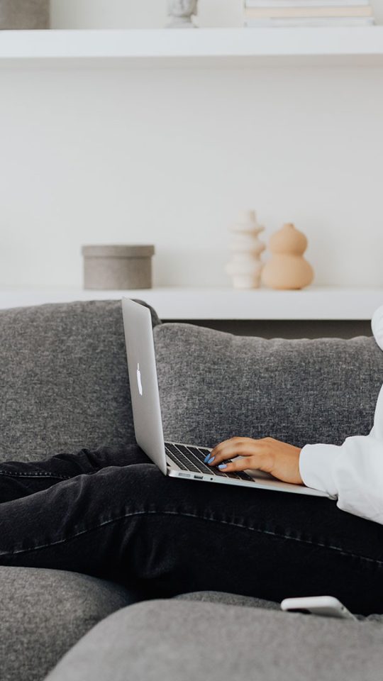 woman sitting on couch with laptop at The  Mark at 2600