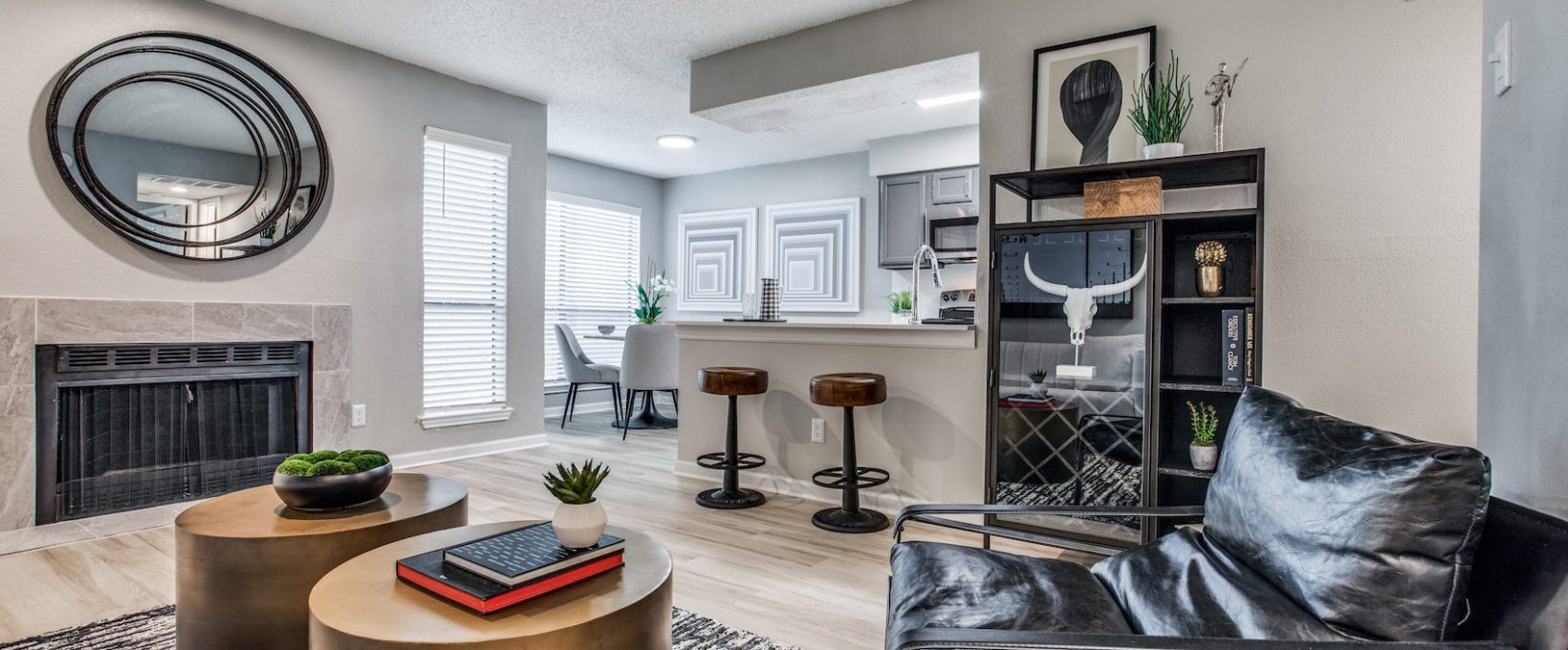 the living room has a fireplace and a black leather couch at The  Republic East & West