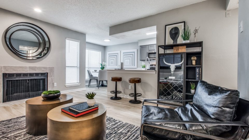 the living room has a fireplace and a black leather couch at The  Republic East & West