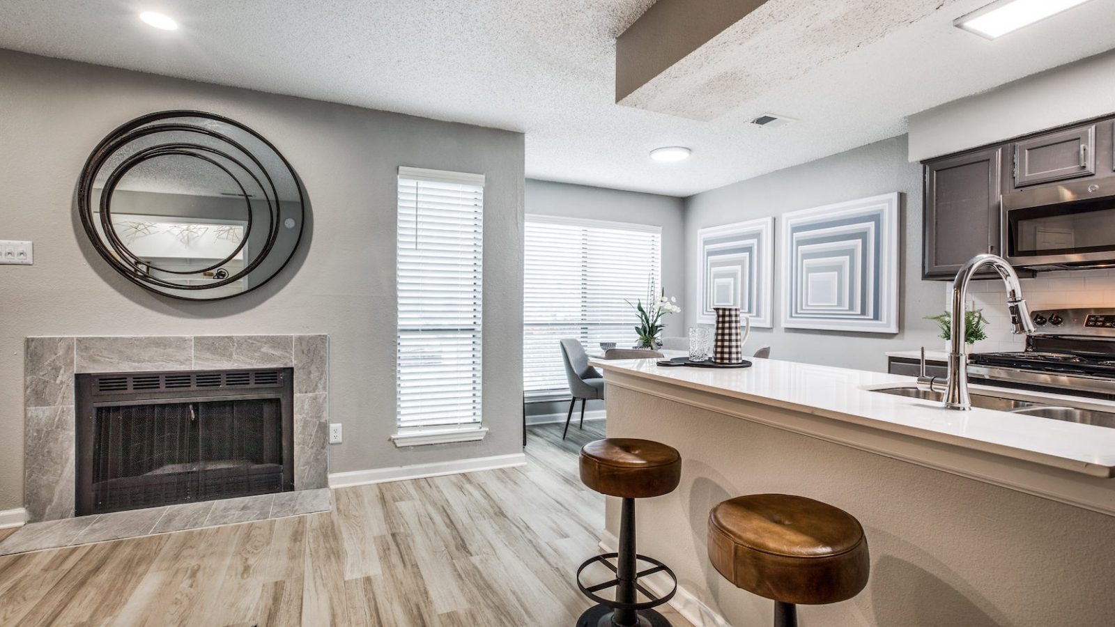 the kitchen has a stove, microwave, and bar stools at The  Republic East & West