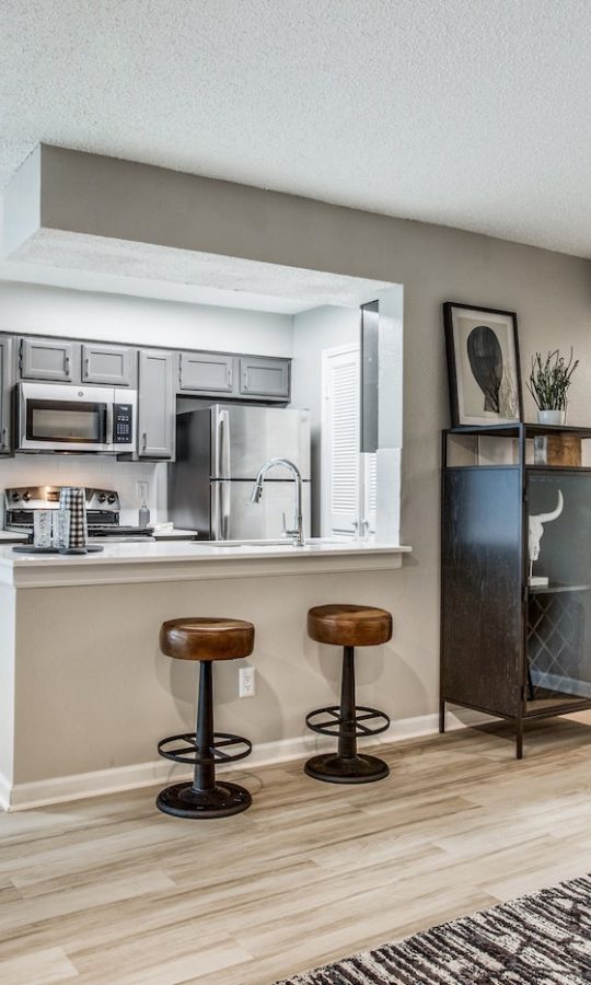 the living room and kitchen area of a new apartment at The  Republic East & West