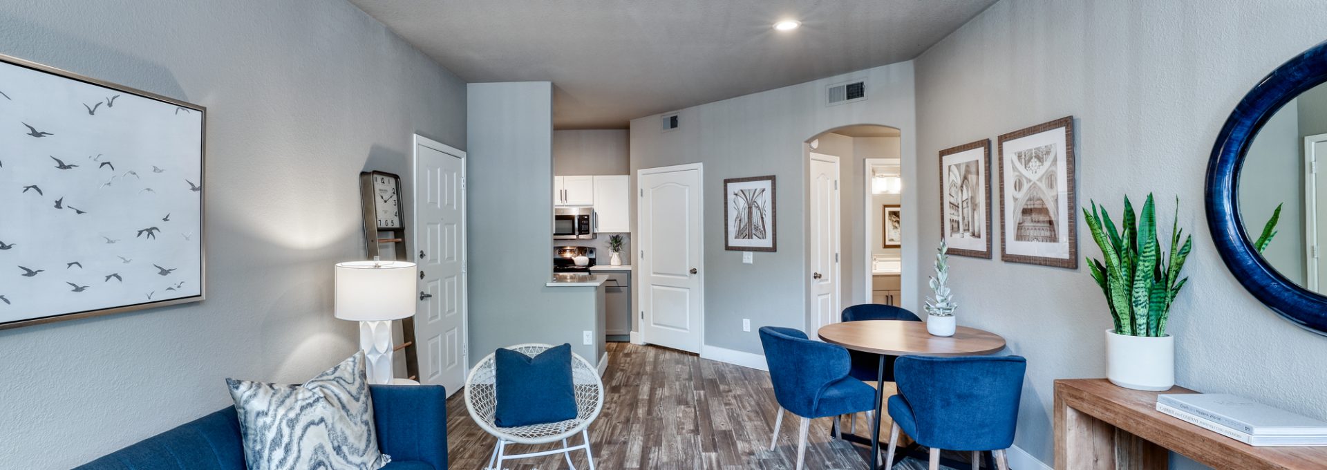 a living room with blue furniture and a ceiling fan at The Oxford