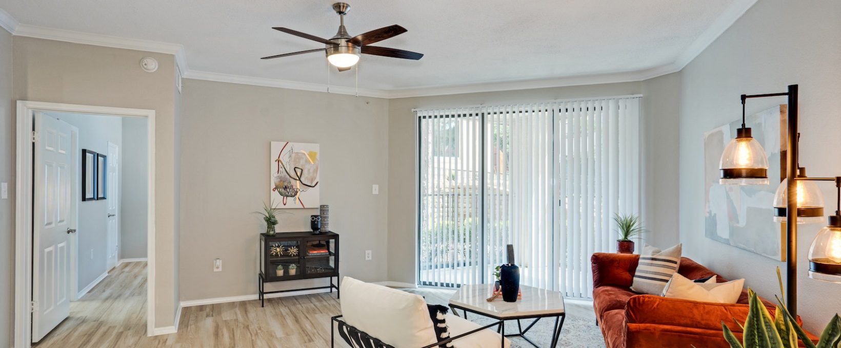 a living room with a ceiling fan and hardwood floors at The  Lana