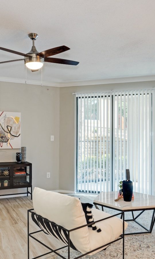 a living room with a ceiling fan and hardwood floors at The  Lana