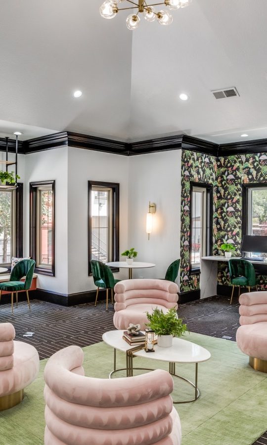 the lobby of a hotel with green chairs and pink walls at The  Lana