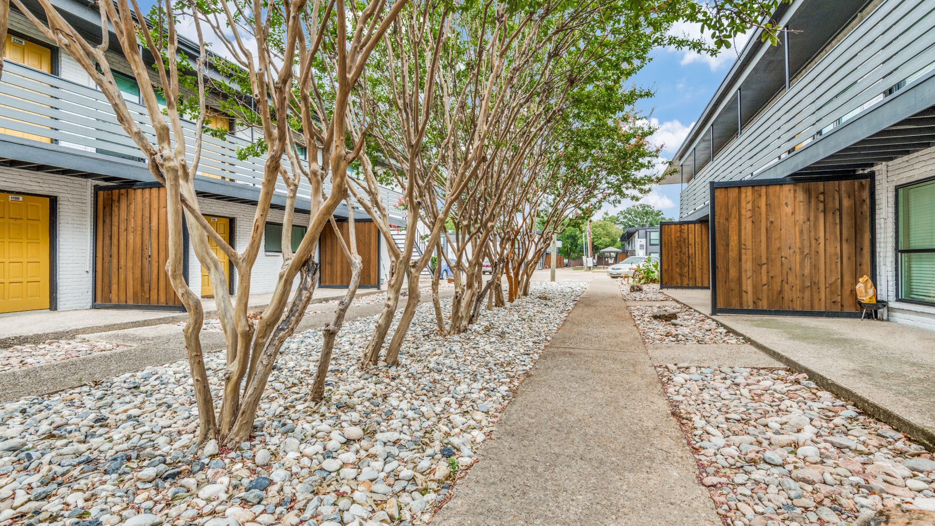 a walkway with trees and rocks in front of a building at The Palmilla