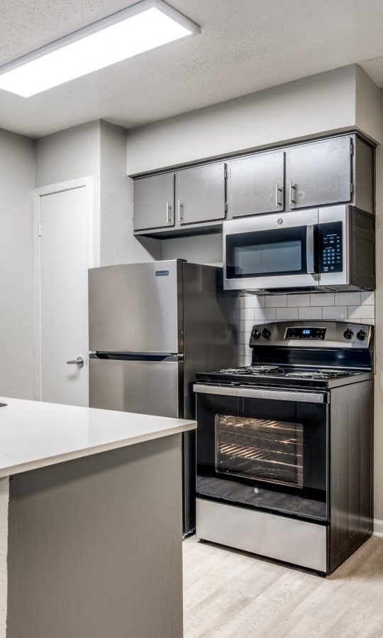 a kitchen with stainless steel appliances and a microwave at The Palmilla
