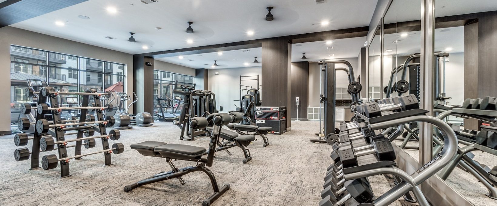 a gym room with exercise equipment and mirrors at The Cedar at  Branch