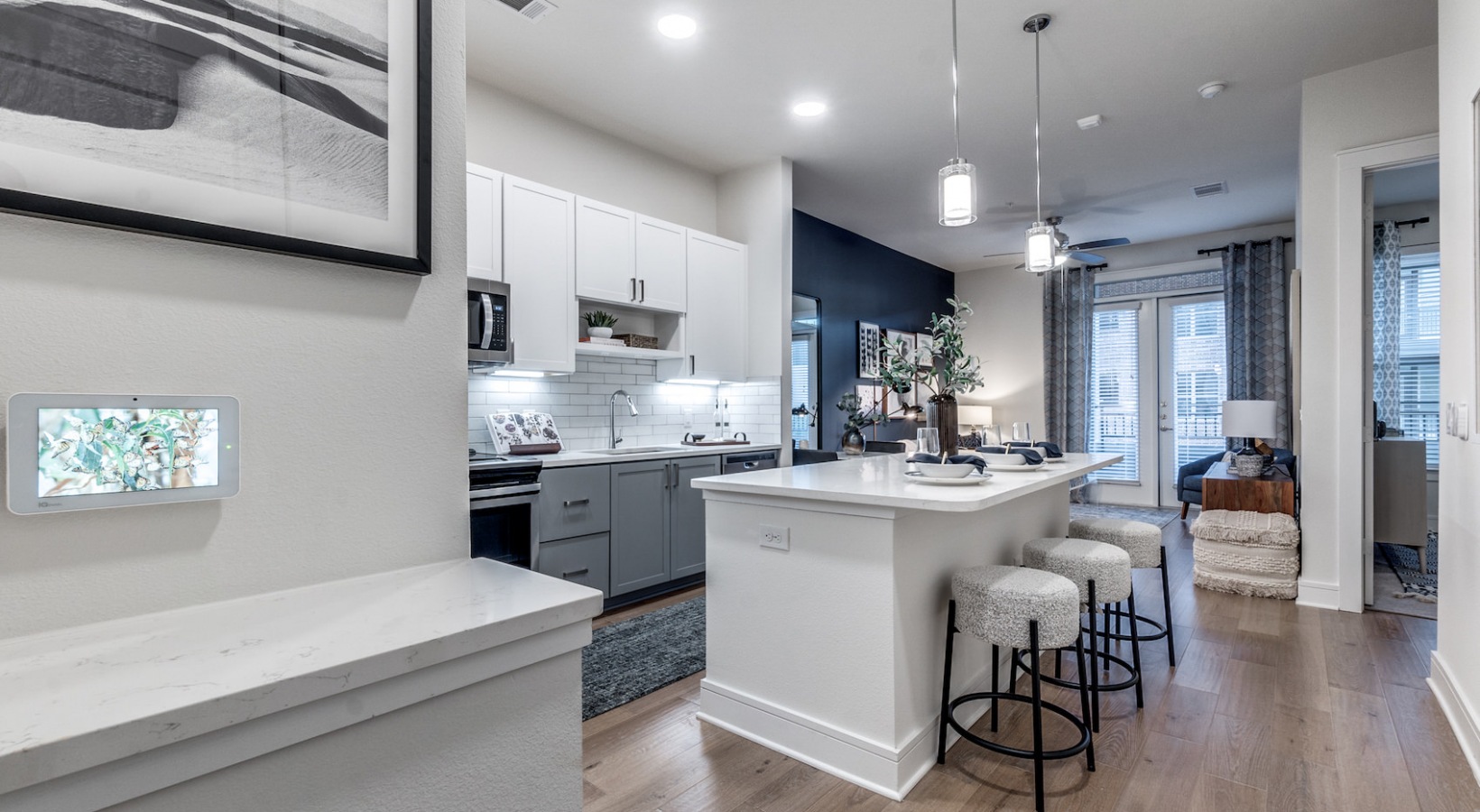 a kitchen with white cabinets and a large island at The Cedar at  Branch