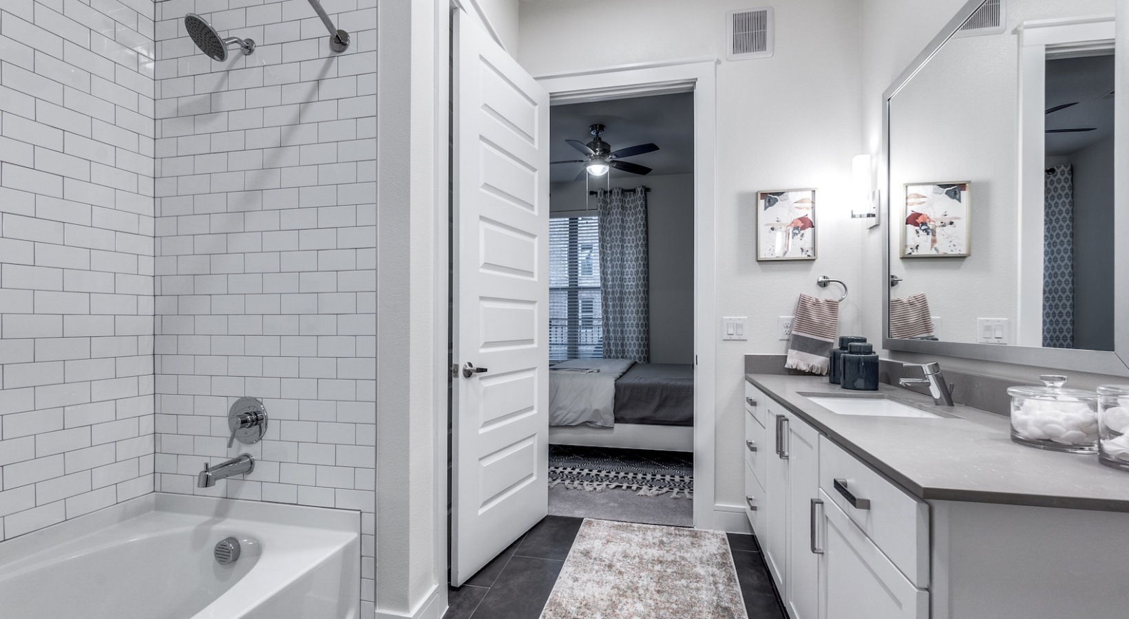 a bathroom with white tile and a tub at The Cedar at  Branch