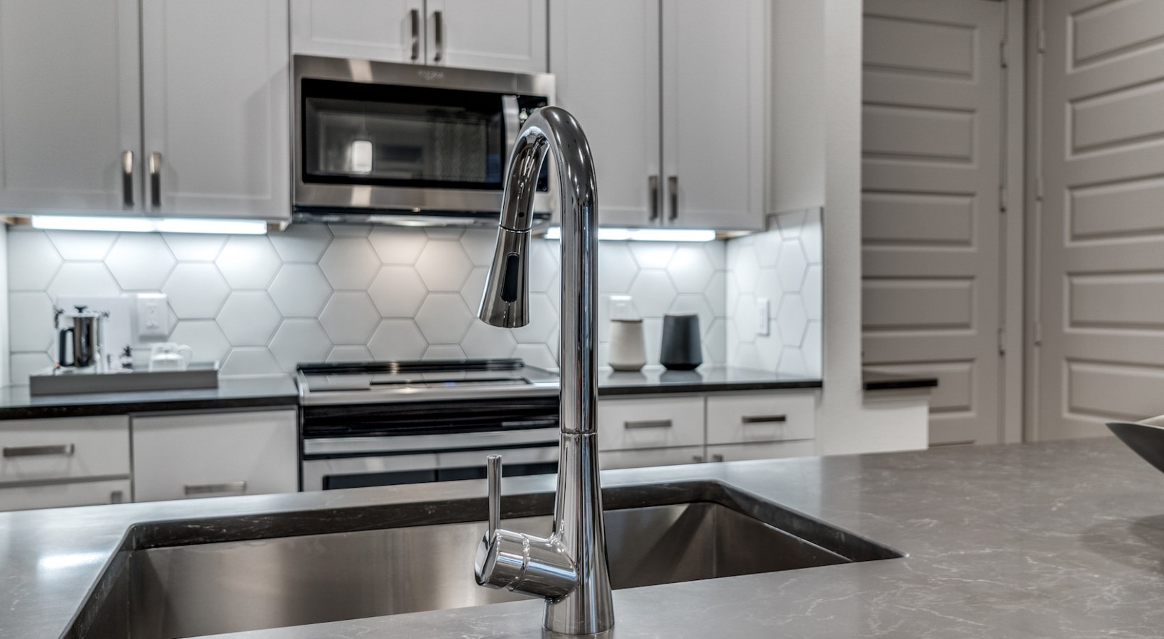 a kitchen with stainless steel appliances and a sink at The Cedar at  Branch