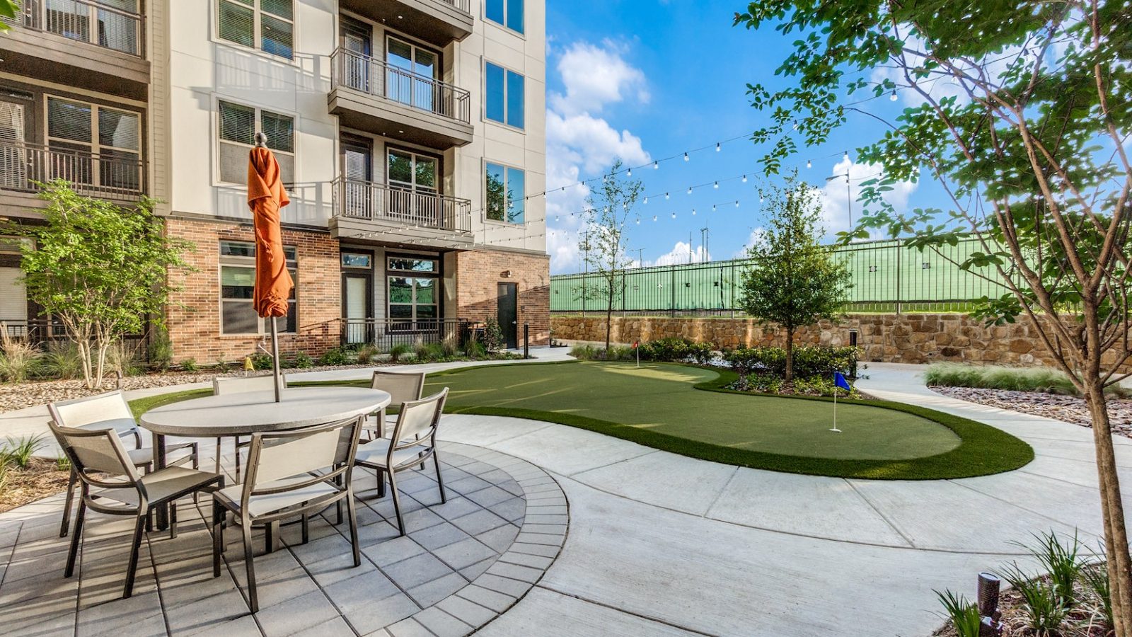 a patio with a putting green and a table at The Cedar at  Branch