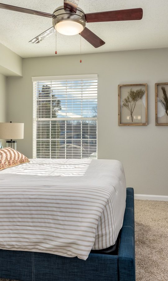a bedroom with a ceiling fan and a bed at The Winslow