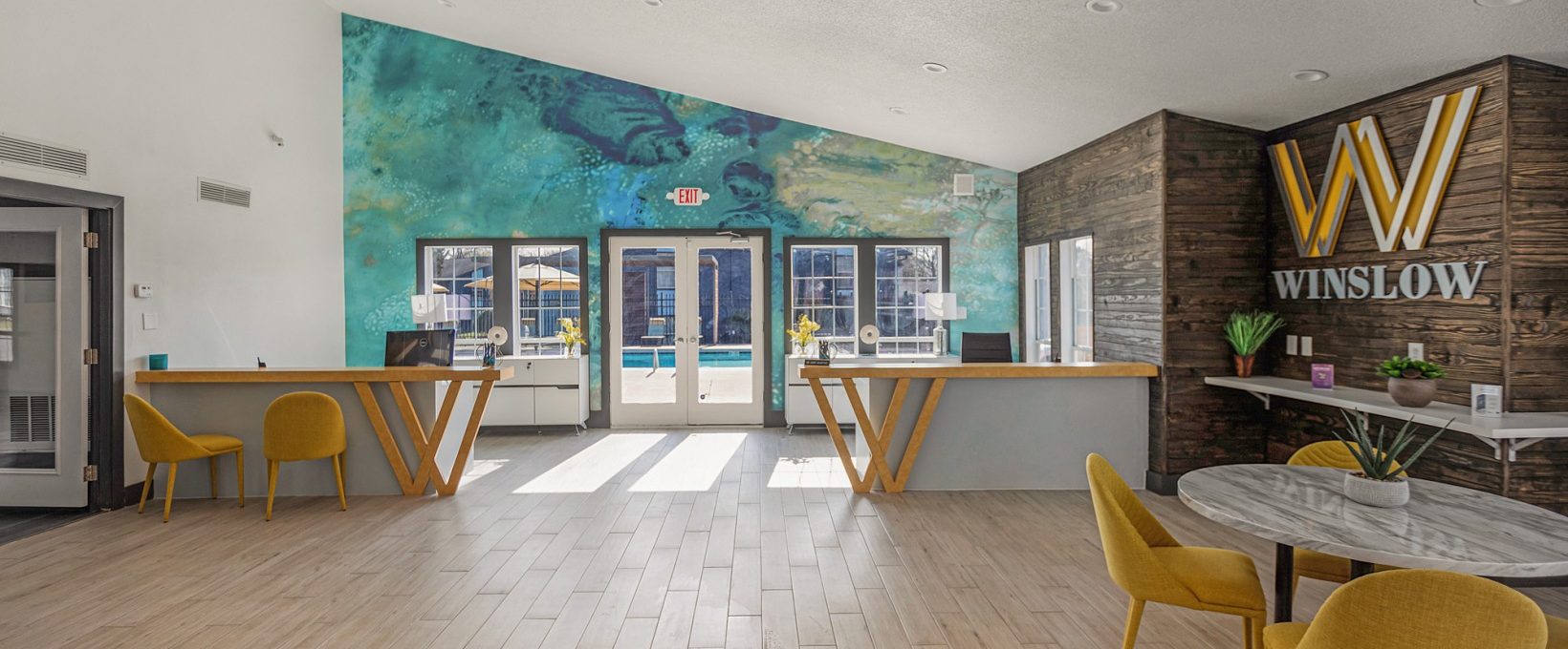 the lobby of a hotel with a large mural on the wall at The Winslow
