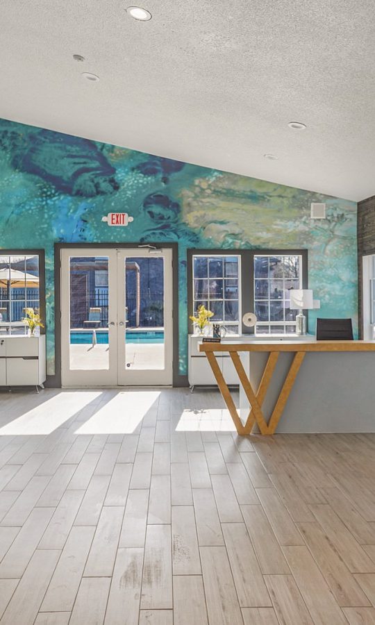 the lobby of a hotel with a large mural on the wall at The Winslow