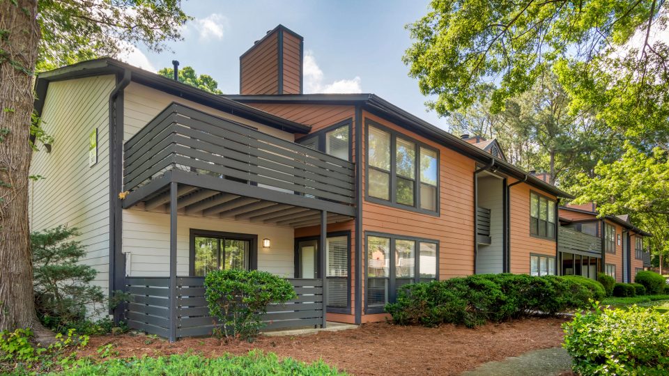 the exterior of an apartment complex with trees and bushes at The  Bowie
