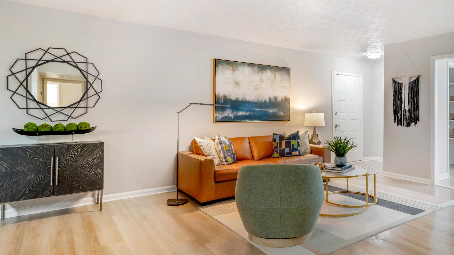 a living room with a couch, coffee table and a mirror at The  Bowie