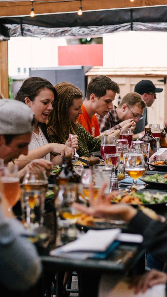 people sitting in front of table talking and eating
