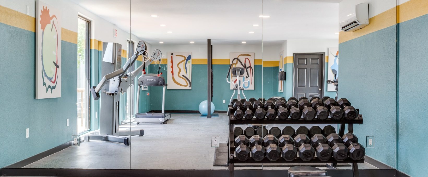 a gym room with exercise equipment and mirrors at The Melville