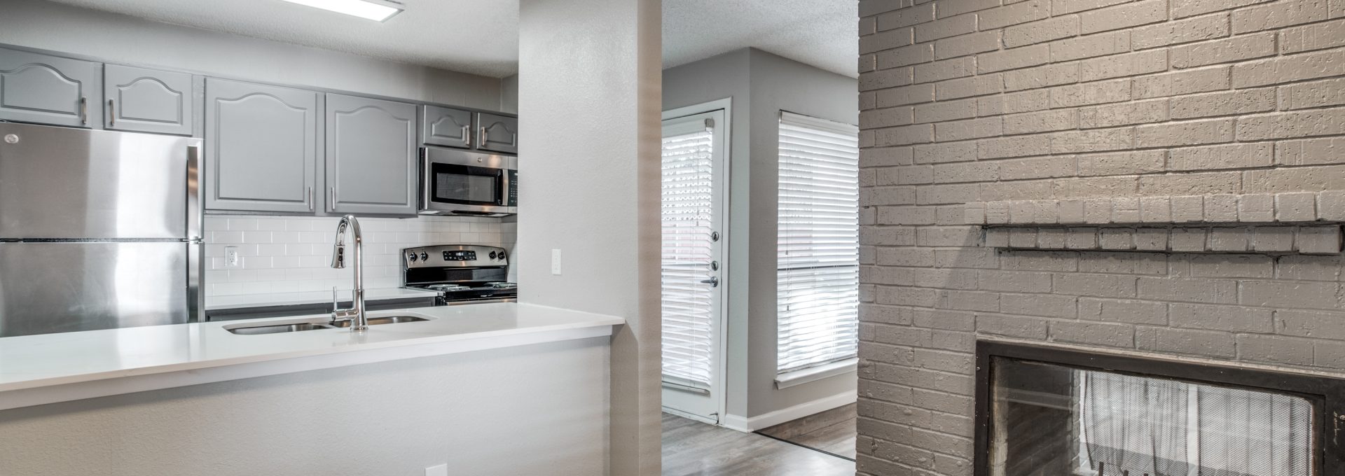 a brick fireplace in a kitchen with a ceiling fan at The Evaline