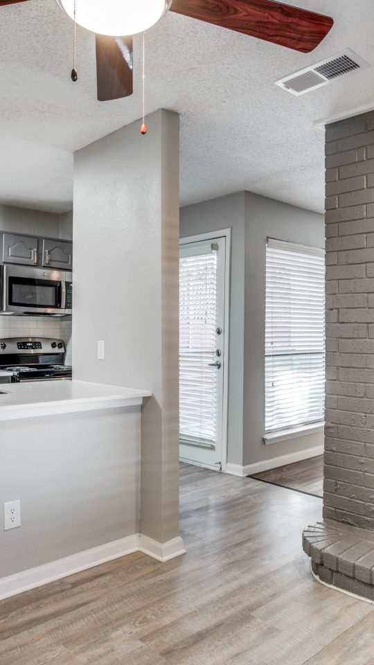 a brick fireplace in a kitchen with a ceiling fan at The Evaline
