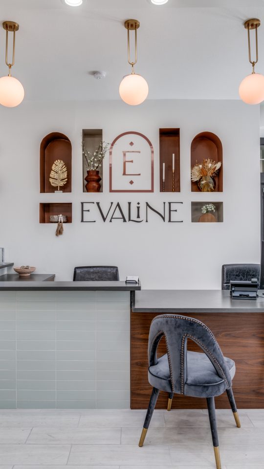 the front desk of a modern office with a large sign at The Evaline