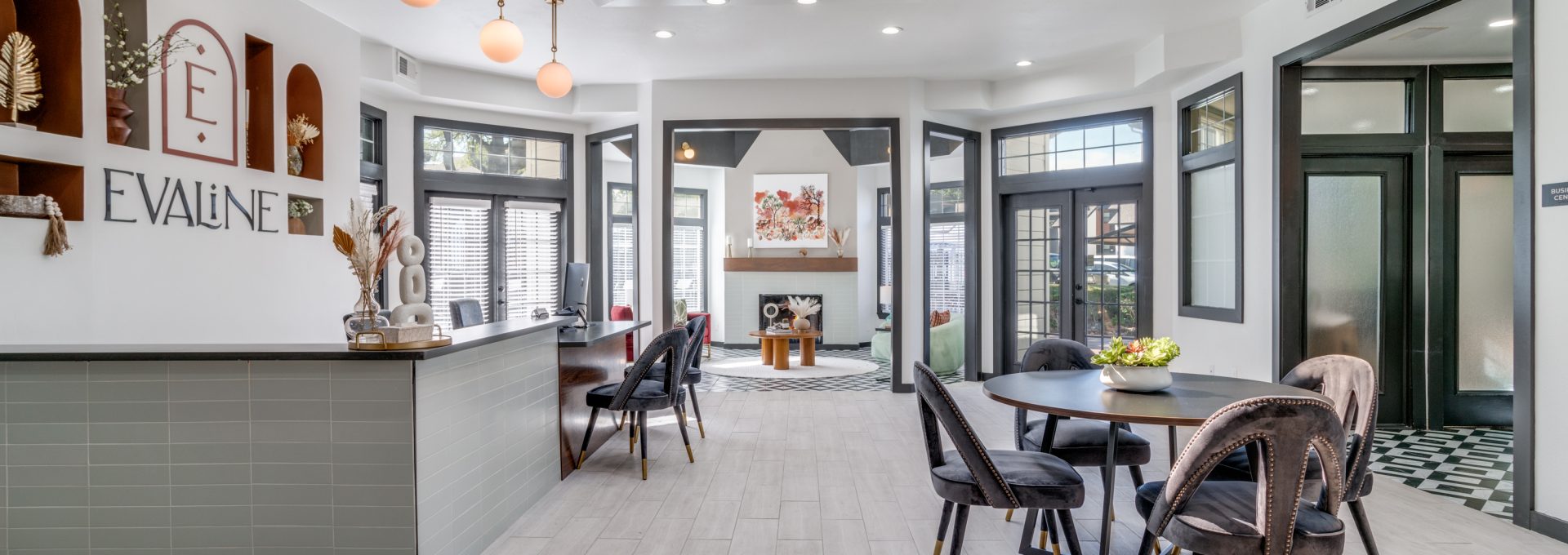 the lobby of a modern apartment building with a large table and chairs at The Evaline