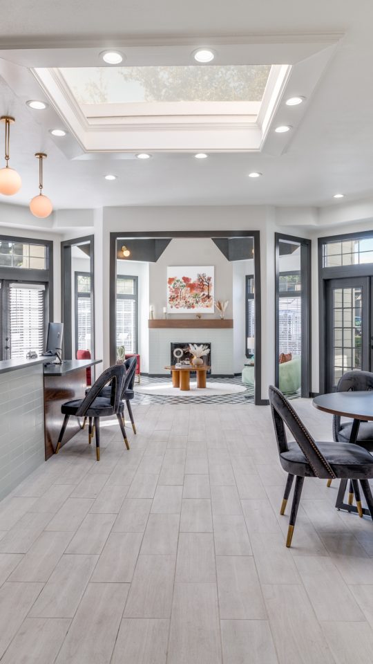 the lobby of a modern apartment building with a large table and chairs at The Evaline