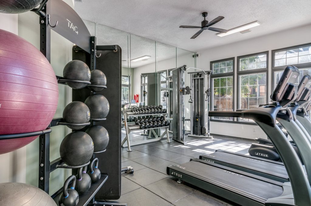 a gym room with exercise equipment and mirrors at The Evaline