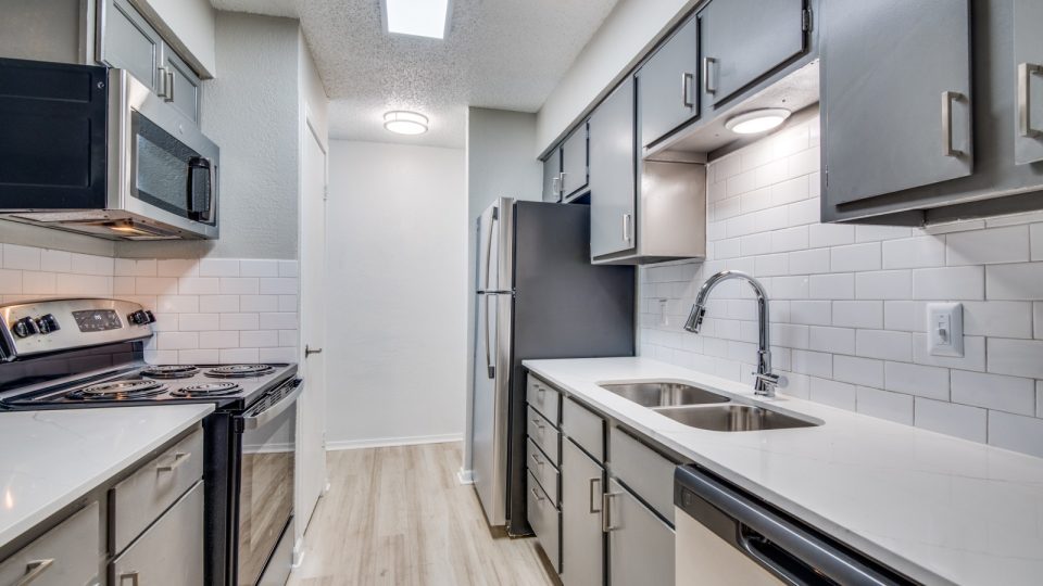 kitchen with stainless steel appliances and white cabinets at The  Booker