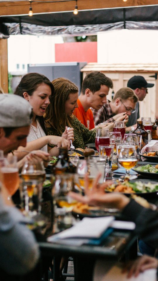 people sitting in front of table talking and eating