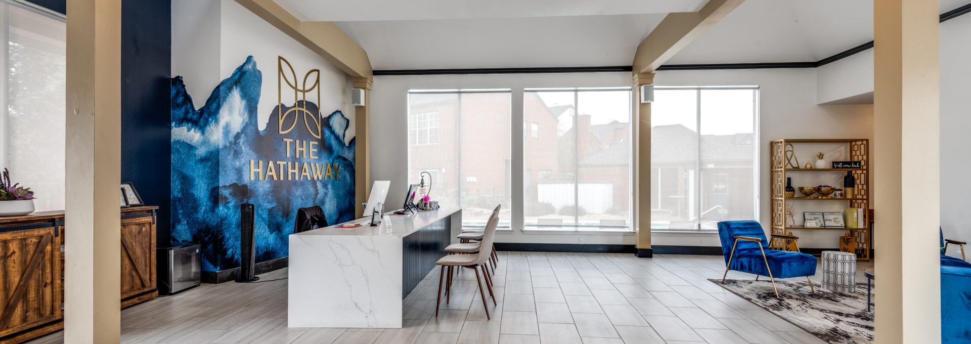 the lobby of a building with blue walls and a large mural at The  Hathaway at Willow Bend