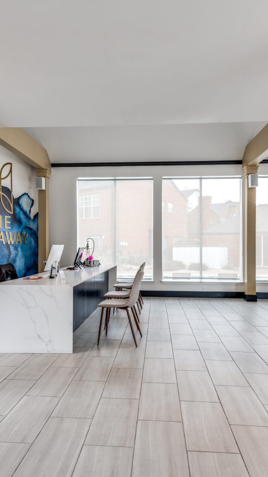 the lobby of a building with blue walls and a large mural at The  Hathaway at Willow Bend