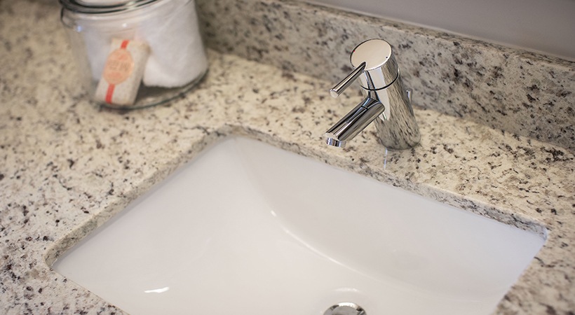 a bathroom sink with a soap dispenser and a toothbrush at The Teak at  Branch