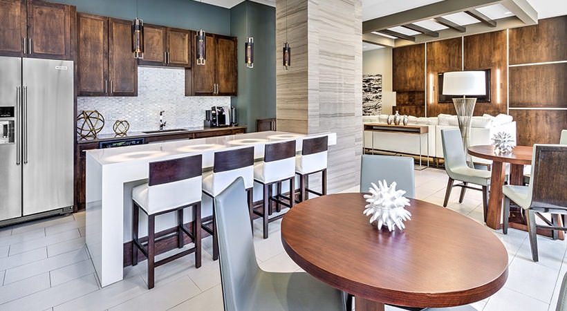 a kitchen and dining area with wood cabinets and stainless steel appliances at The Teak at  Branch