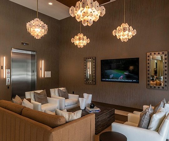 a living room with couches, a television and a chandelier at The Ash at  Branch