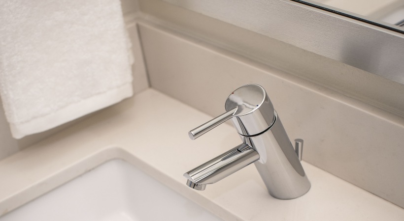 a bathroom sink with a white faucet and a towel at The Ash at  Branch