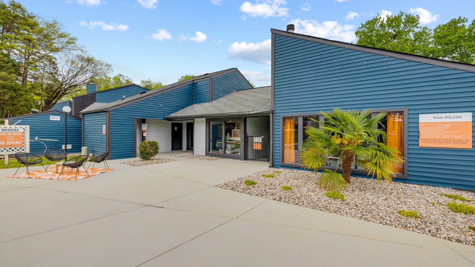 the exterior of a building with blue siding and a sign that says, at The Tatum