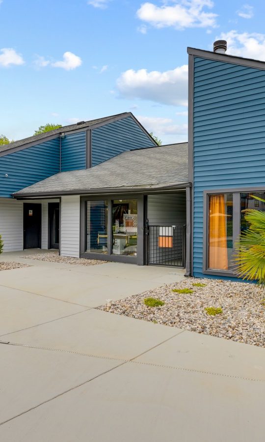 the exterior of a building with blue siding and a sign that says, at The  Tatum