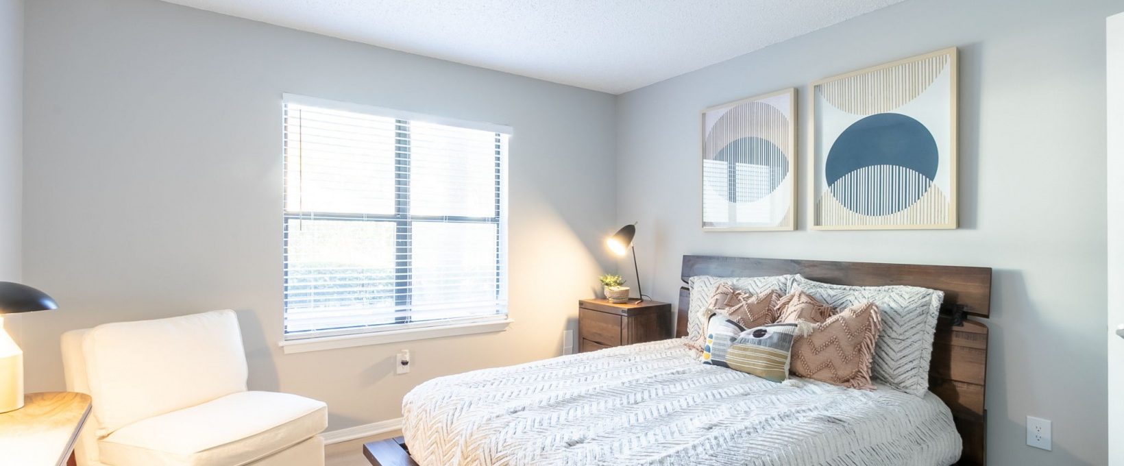 a bedroom with a bed, chair and nightstand at The  Rowen