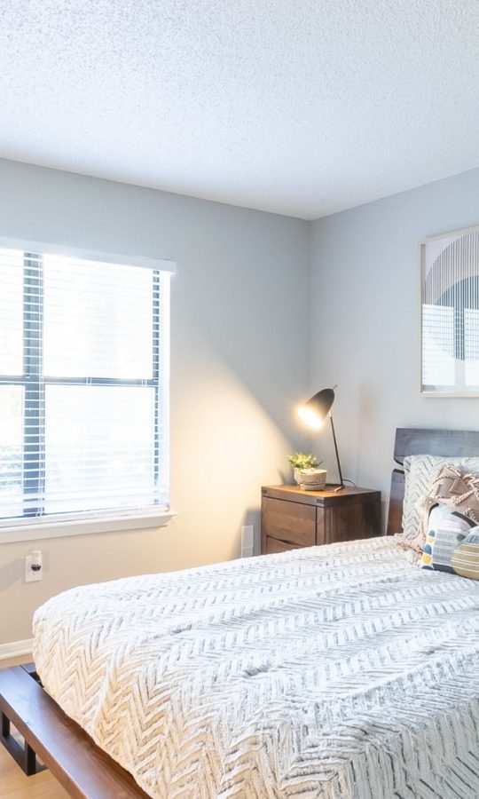 a bedroom with a bed, chair and nightstand at The  Rowen